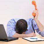 Business Man Slumped Over Desk Due To Being Overworked