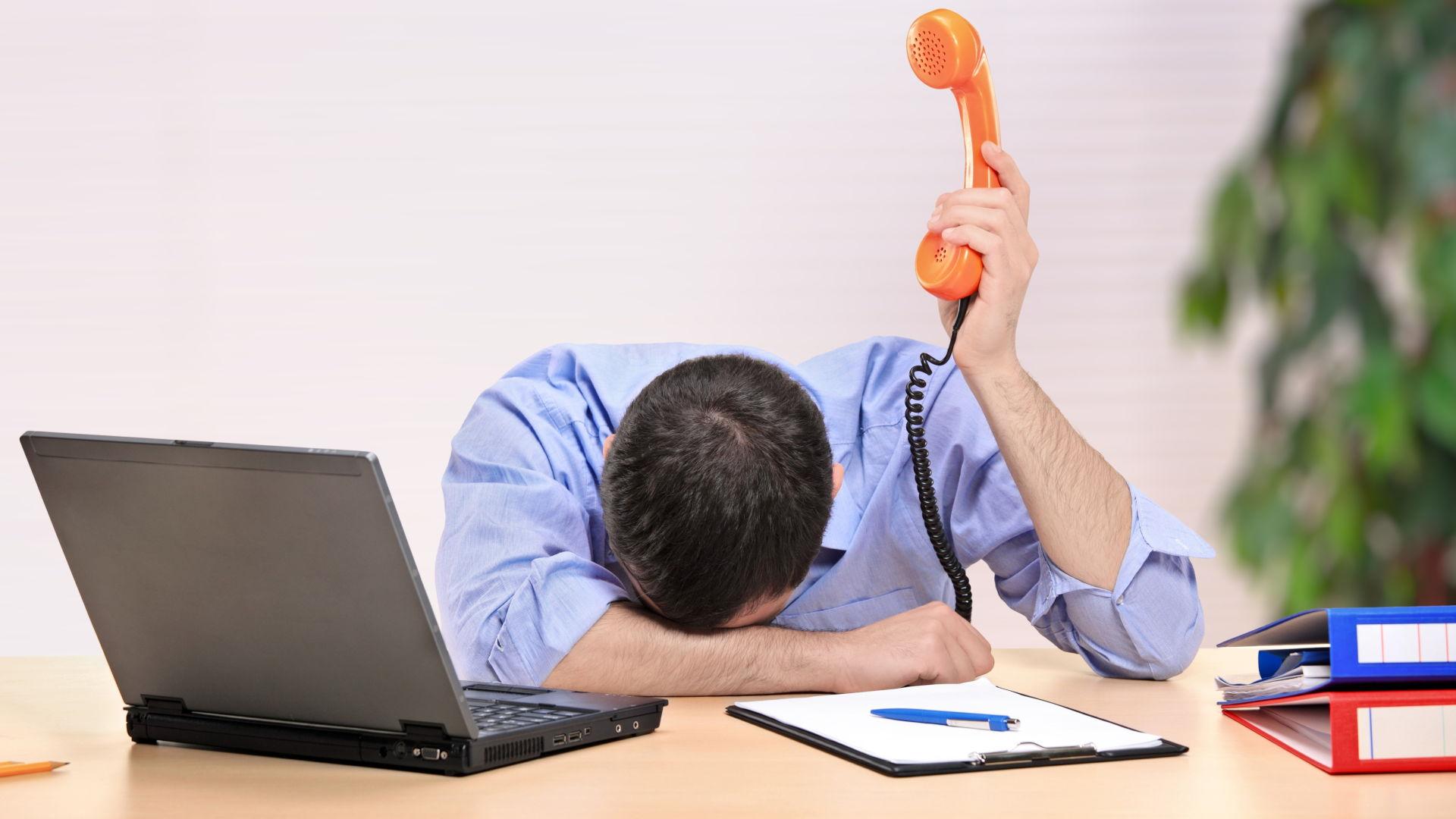 Business Man Slumped Over Desk Due To Being Overworked