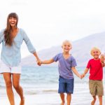 Man and Woman walking accross the beach with their 2 children