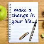 Notepad On A Wooden Table With The Text Make A Change In Your Life