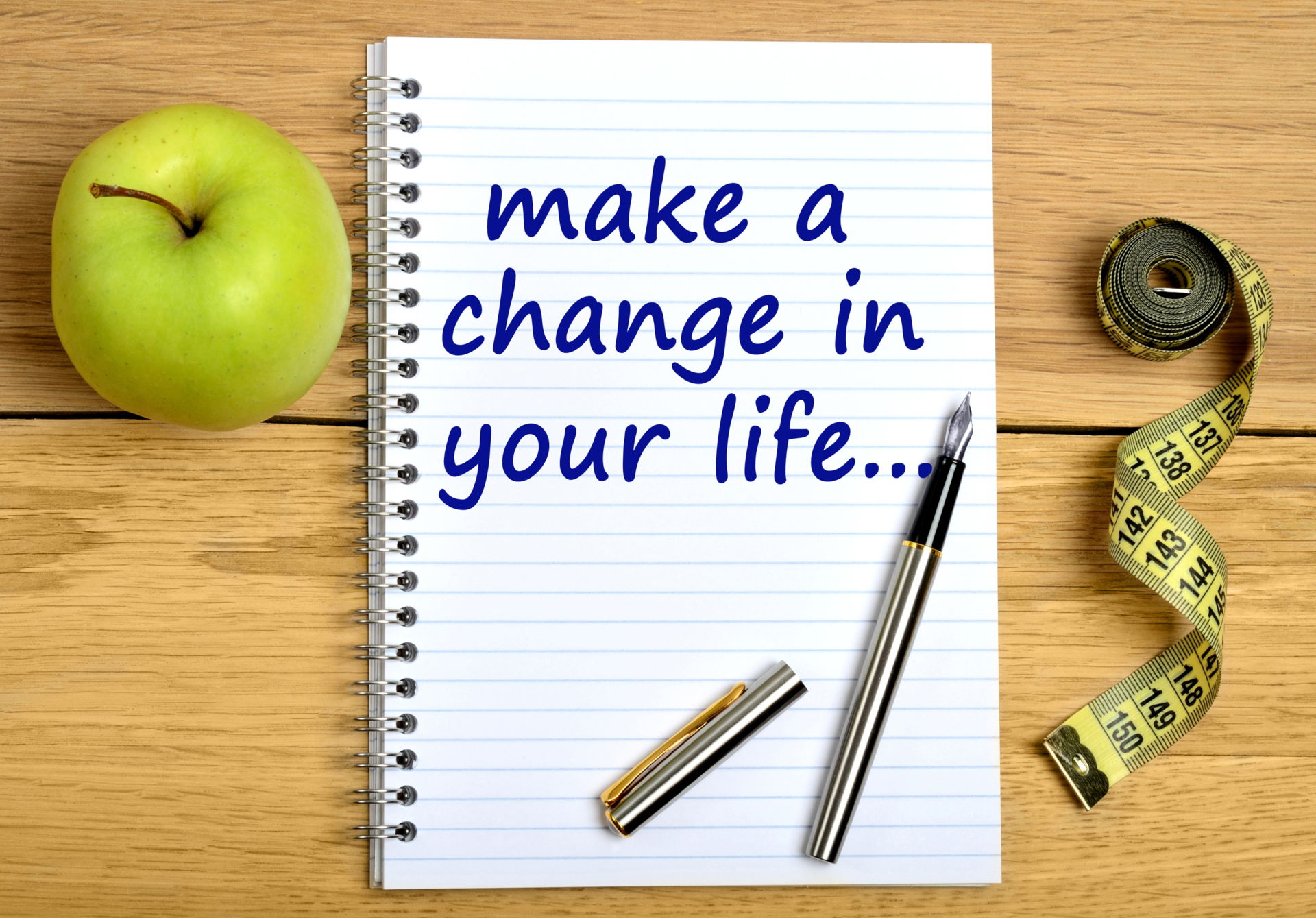 Notepad On A Wooden Table With The Text Make A Change In Your Life