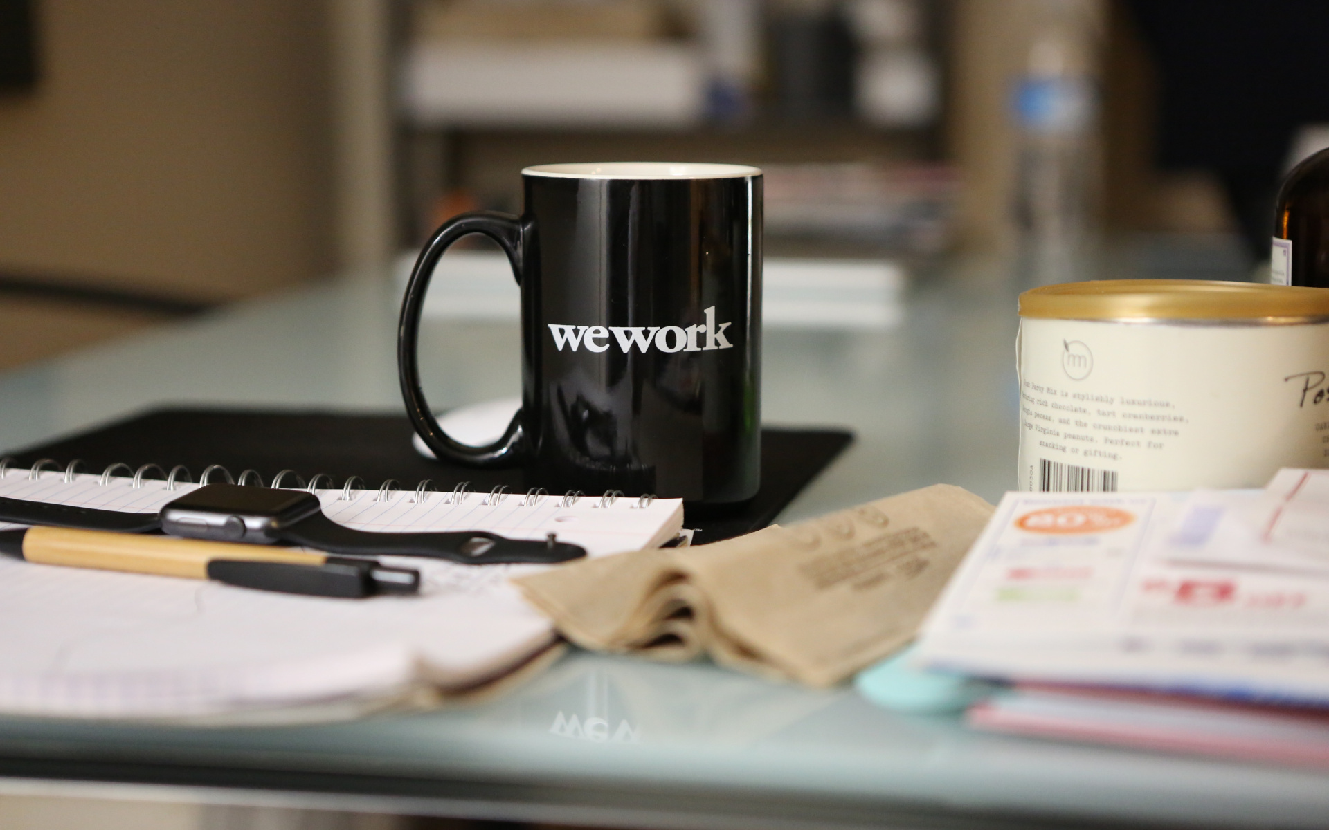 Office Desk With Papers, Pens And A Coffee Mug With The Caption Wework