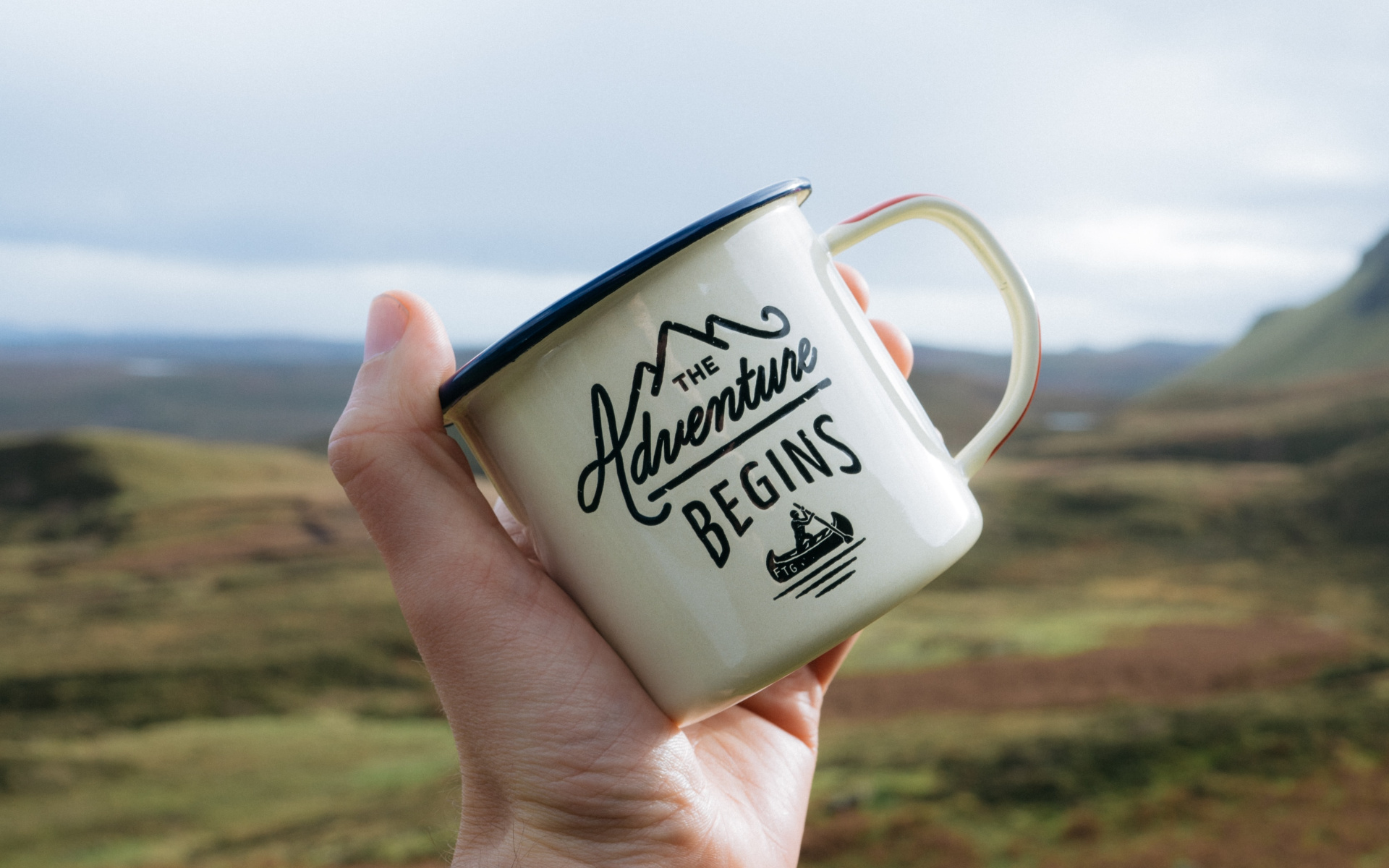 Guy Holding Mug With Slogan The Adventure Begins