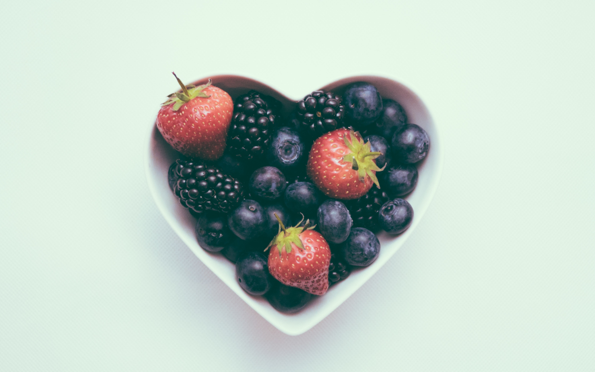 Heart Shaped Bowl With Fruit On A White Background