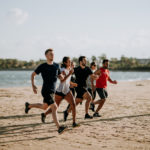 Men And Women Running On A Beach