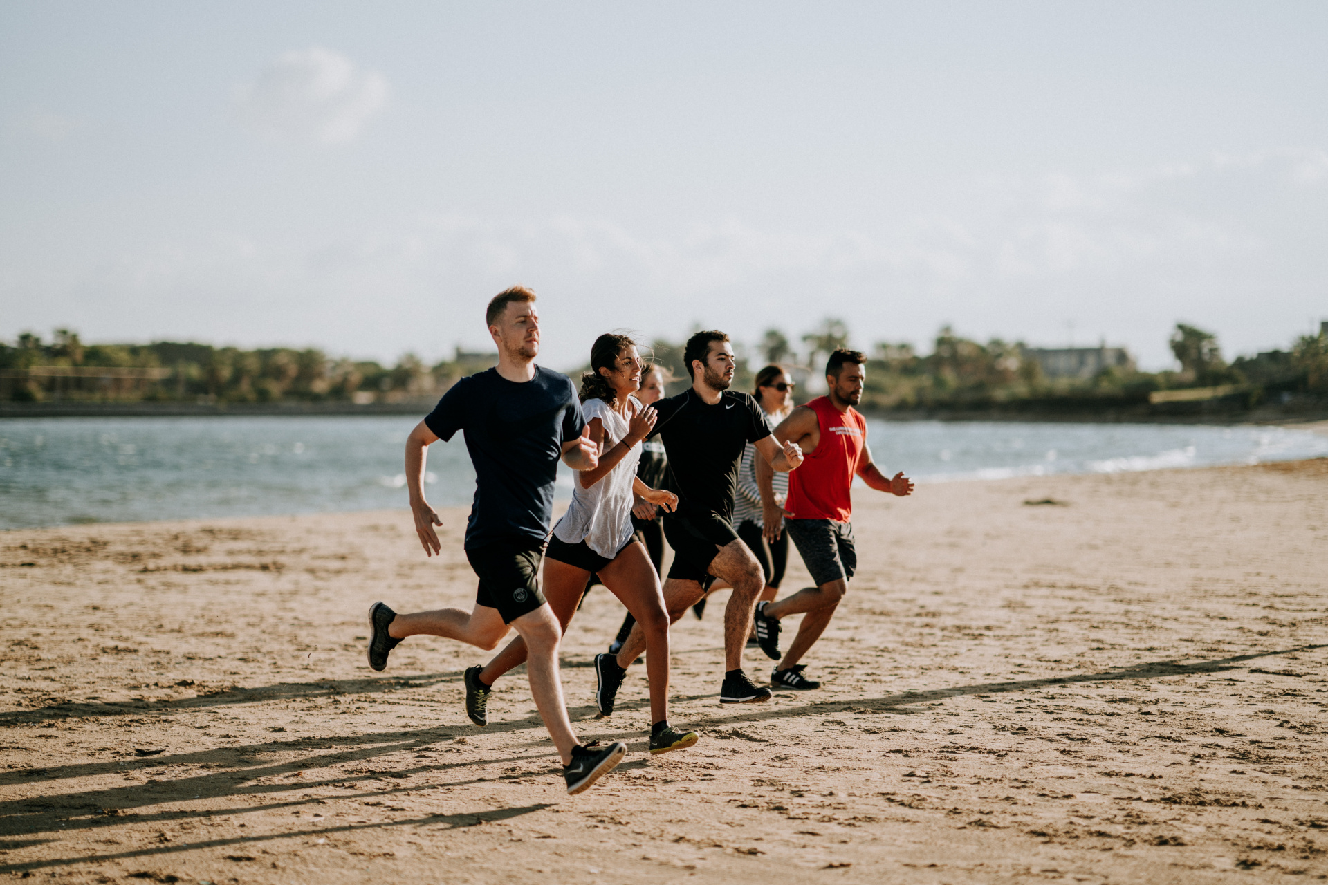 Men And Women Running On A Beach