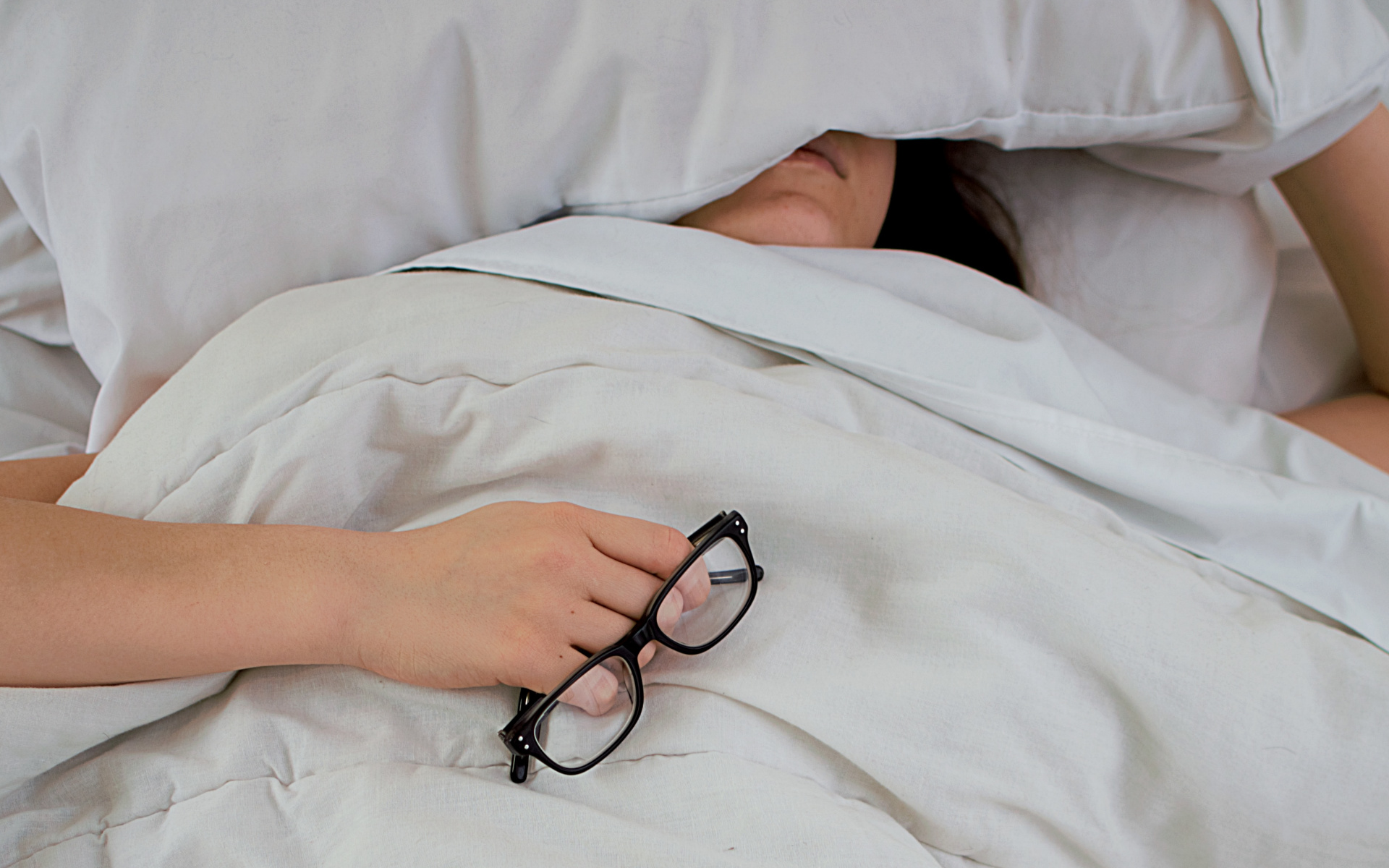 Woman Sleeping In Bed With Pillow Over Her Face
