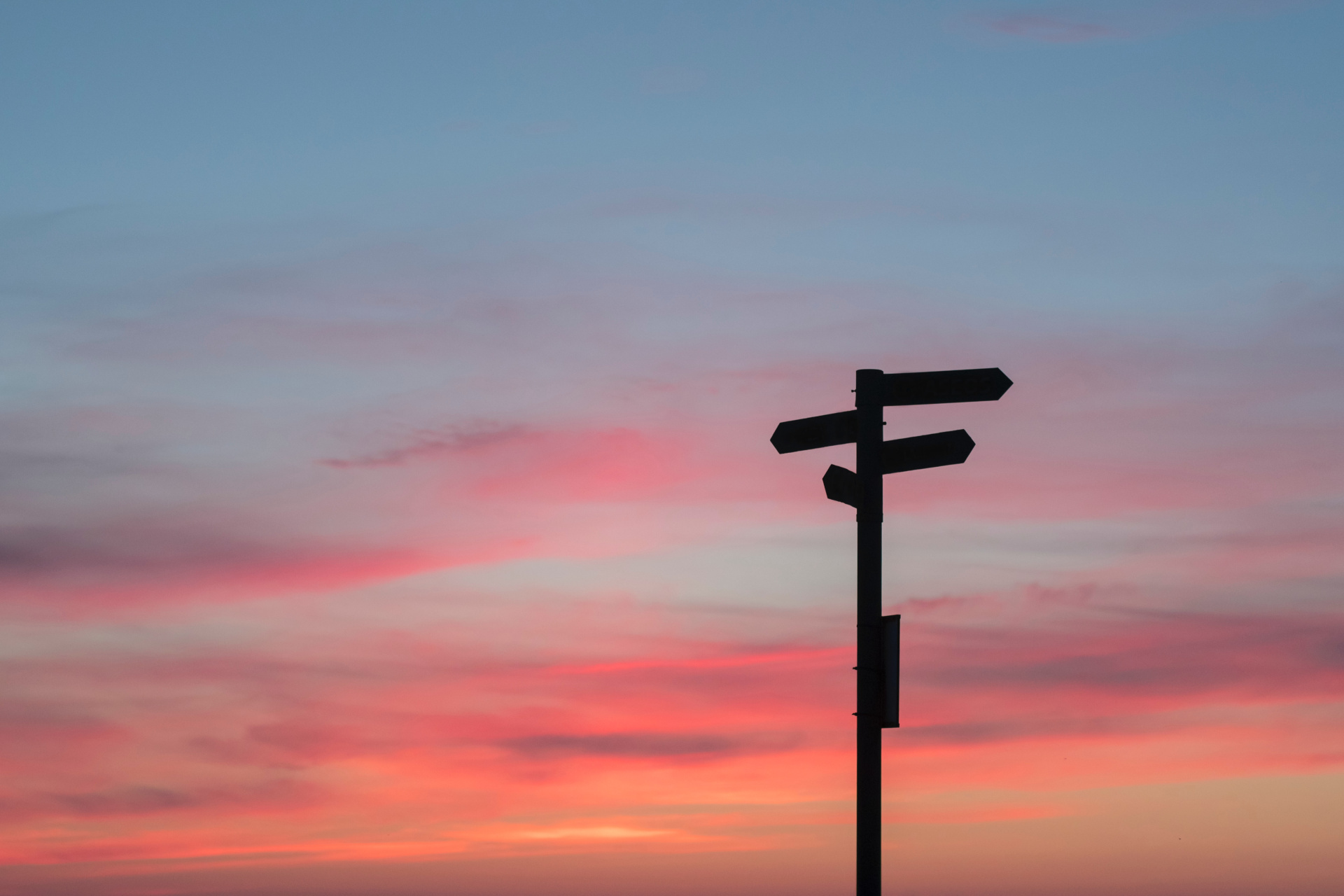 Silhouette Of Sign Post On Red Sky