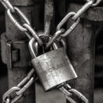 Iron Gate with a Steel Padlock Locking Chains Together